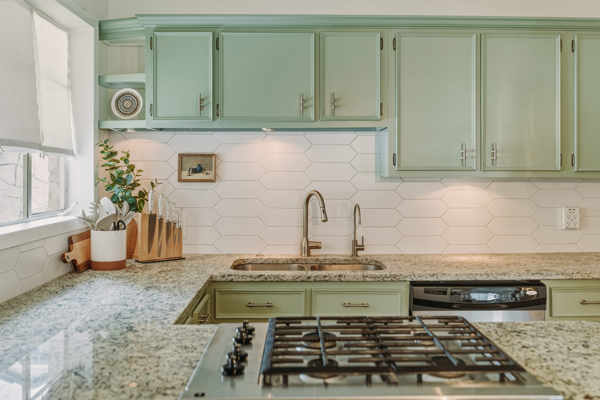 Detail of sage cabinets, picket-tile backsplash, and granite-surround sink at Casa Thorman