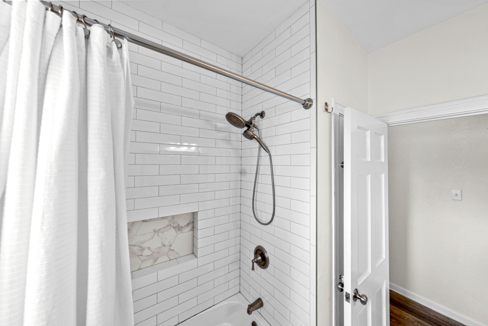 Subway-tiled shower with marble hexagon niche at Casa Thorman