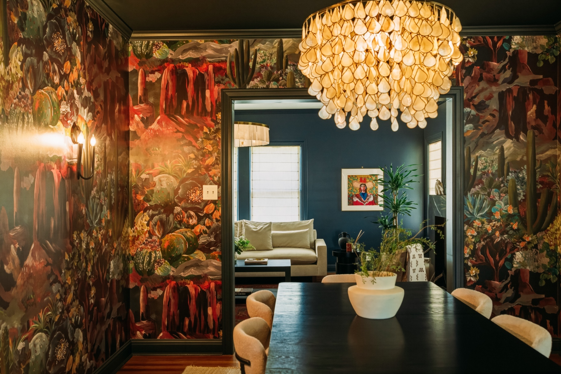 Wide dining room view with desert mural, capiz chandelier, and doorway into the living room at Casa Thorman
